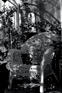 a black and white photo of two wicker chairs